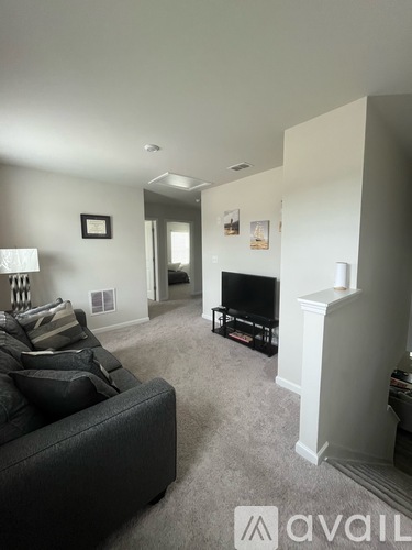 A living room with a grey couch and a fireplace.
