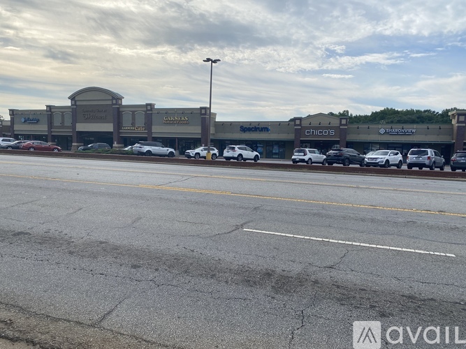 A parking lot in front of a building with several cars parked.