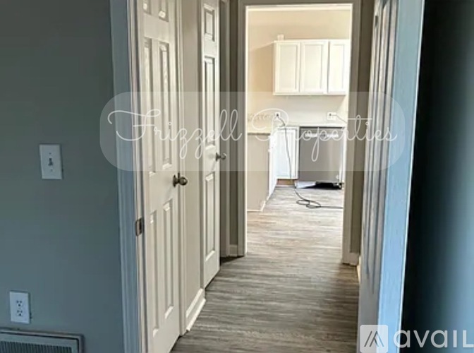 A hallway with a white door and a wall-mounted shelf.