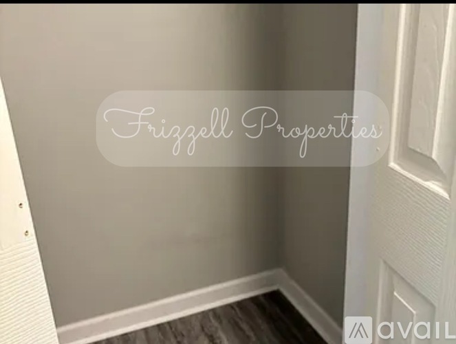 A hallway with a wooden floor and a white door.