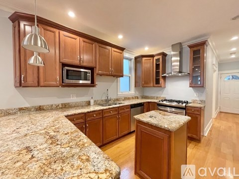 A kitchen with wooden cabinets and granite countertops.