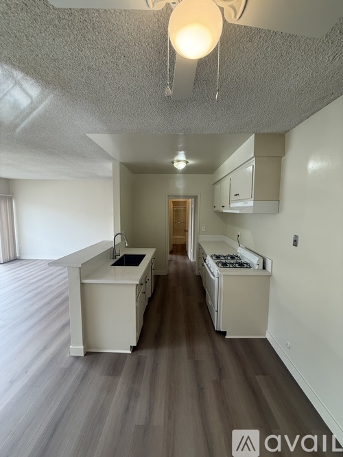 A kitchen with a white counter and a stove top oven.