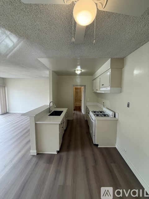 A kitchen with a white counter and a stove top oven.