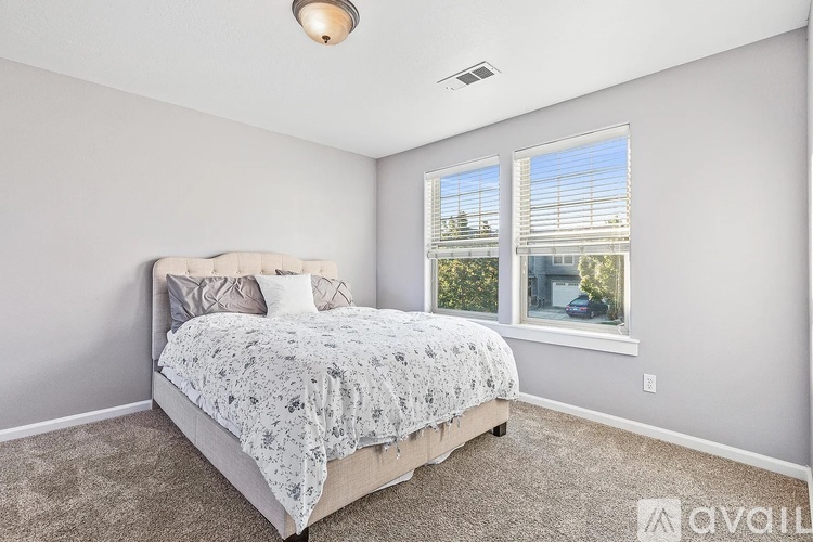 A bedroom with a large bed and a window overlooking a street.