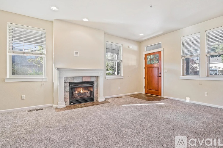 A living room with a fireplace and a carpeted floor.