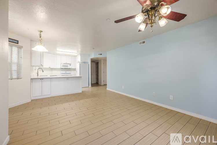 A spacious room with a ceiling fan and lighting fixture.