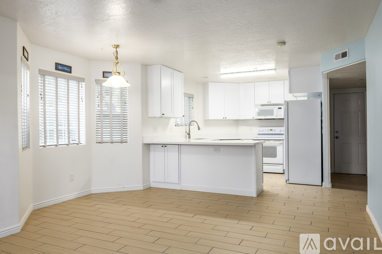 A kitchen with white cabinets and a refrigerator.