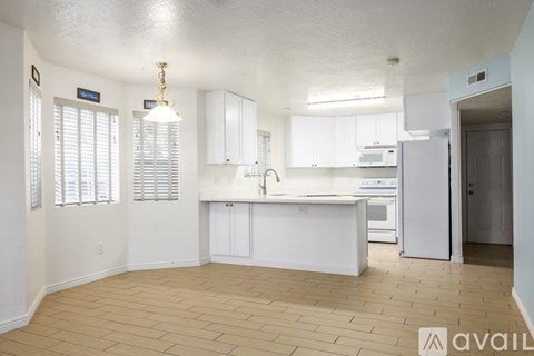 A kitchen with white cabinets and a refrigerator.
