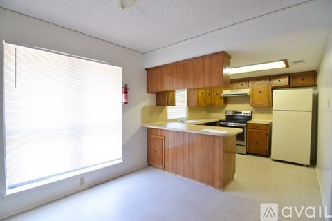 A kitchen with wooden cabinets and a white refrigerator.