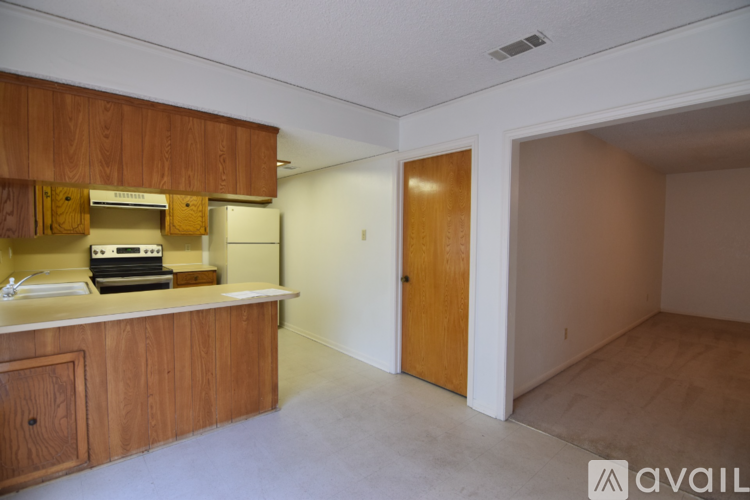 A kitchen with wooden cabinets and a countertop is available for rent.