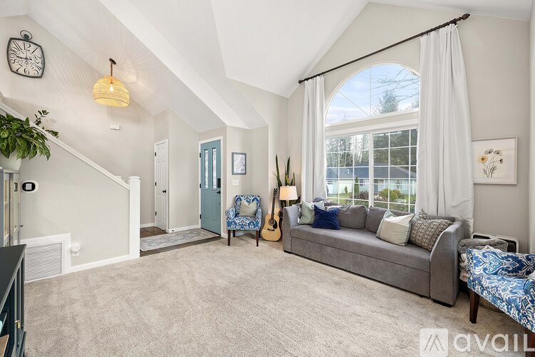 A living room with a grey couch and a blue chair.