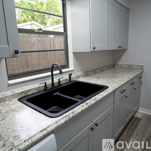 A kitchen with granite countertops and white cabinets.