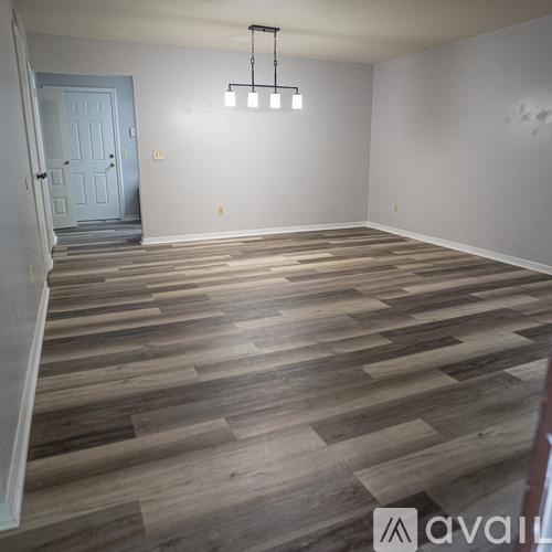 A room with wooden flooring and a chandelier.
