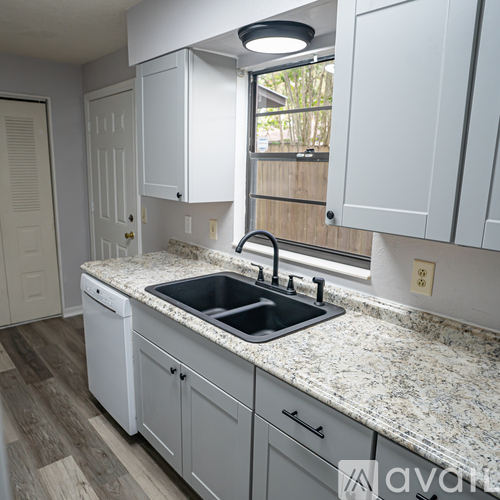 A kitchen with white cabinets and a granite countertop.
