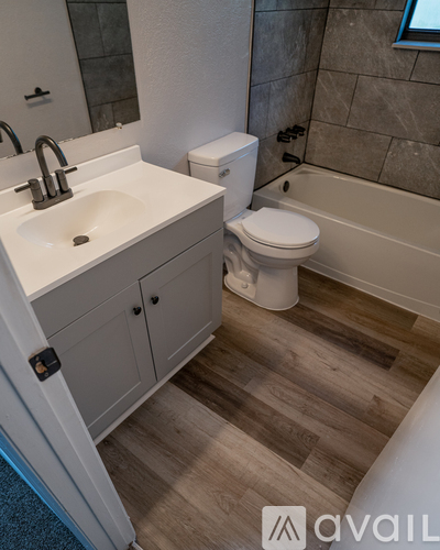 A bathroom with a sink, toilet, and bathtub.