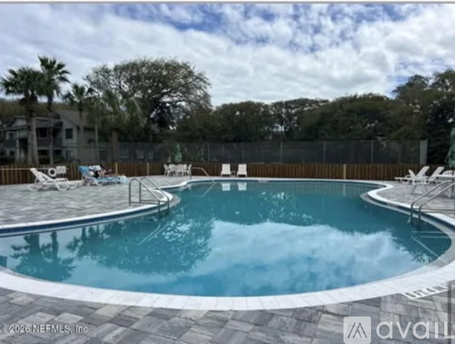 A pool with a ladder and a sign on the fence.