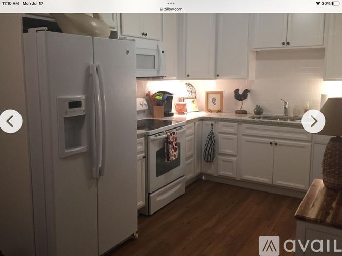 A kitchen with white cabinets and a white refrigerator.