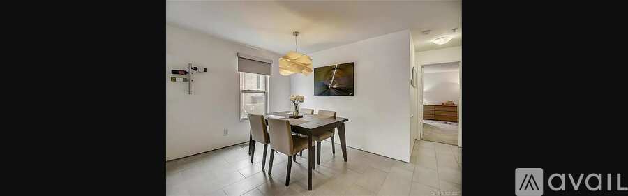 A modern dining room with a wooden table and chairs.