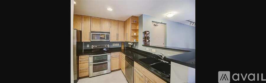 A kitchen with wooden cabinets and black countertops.