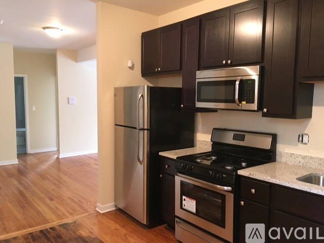 A kitchen with black cabinets and stainless steel appliances.