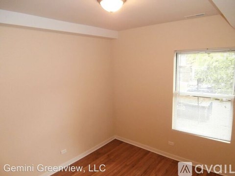 A room with a window and wooden flooring is available for rent.
