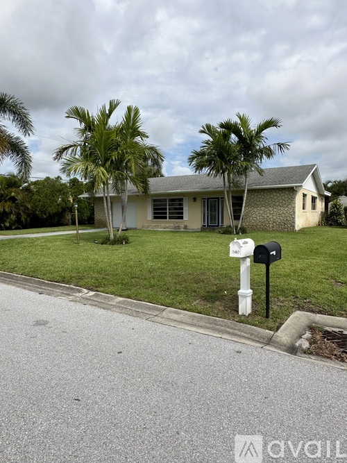 A house with a white fence and a mailbox on the side.