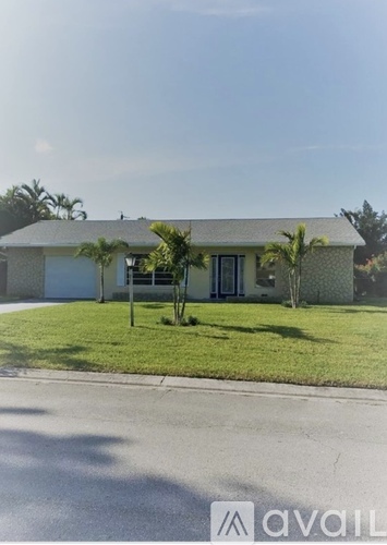 A house with a lawn and trees in front of it.