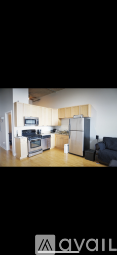 A kitchen with wooden cabinets and a black couch.