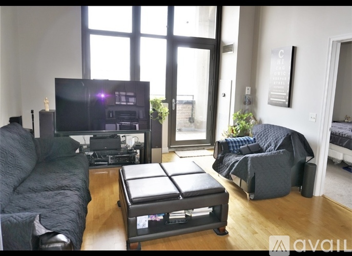 A living room with a black couch and a television.