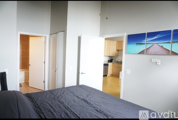 A bedroom with a bed and a painting on the wall.