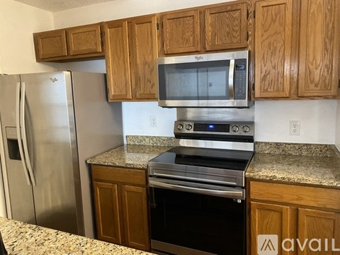A kitchen with wooden cabinets and stainless steel appliances.