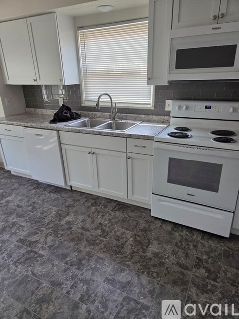 A kitchen with white appliances and cabinets.