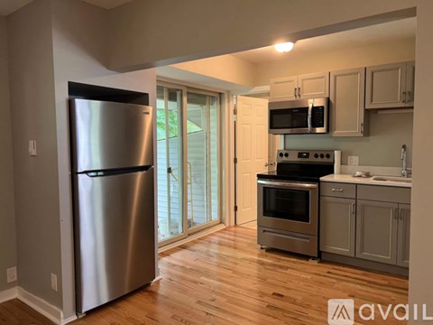 A kitchen with a stainless steel refrigerator and wooden floors.