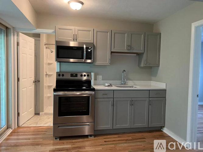 A kitchen with a stove top oven and microwave above it.