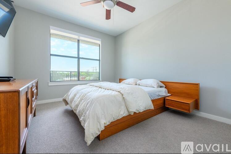A bedroom with a large bed and a ceiling fan.