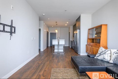 A living room with a black couch and a wooden cabinet.