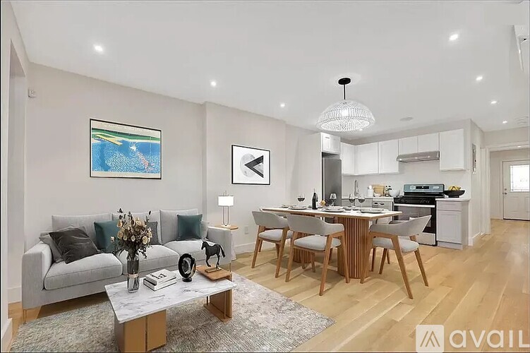 A modern living room with a grey sofa, a wooden coffee table, and a dining area in the background.