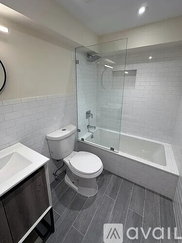 A modern bathroom with a toilet, sink, and bathtub.