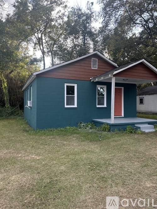 A small house with a red door and a porch.