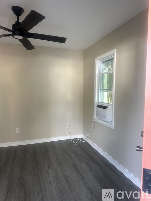A room with a ceiling fan and a window.