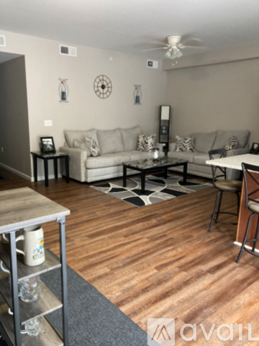 A living room with a couch, a coffee table, and a ceiling fan.