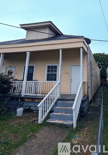 A small house with a porch and a sign that says "2714".