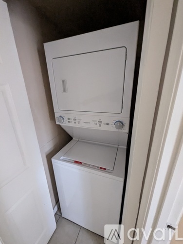 A white dryer and washing machine in a small space.