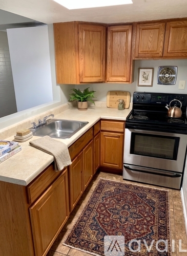 A kitchen with wooden cabinets and a rug on the floor.
