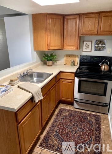 A kitchen with wooden cabinets and a rug on the floor.