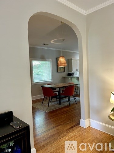 A living room with a television and a dining table with chairs.