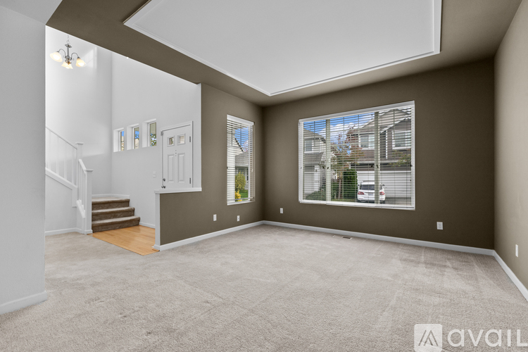 A spacious living room with a carpeted floor and a large window.