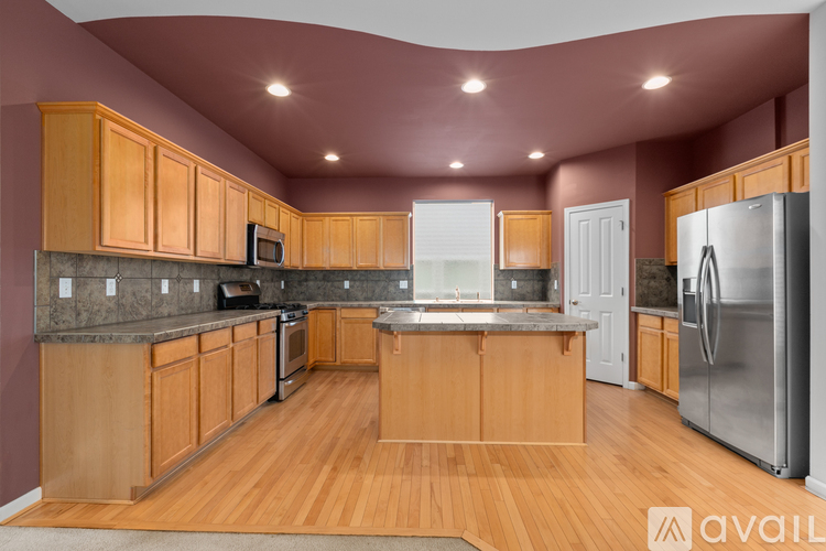 A kitchen with wooden cabinets and a refrigerator.