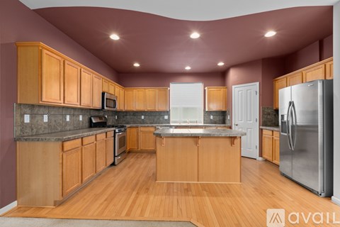 A kitchen with wooden cabinets and a refrigerator.