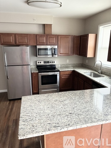 A kitchen with a granite countertop and stainless steel appliances.